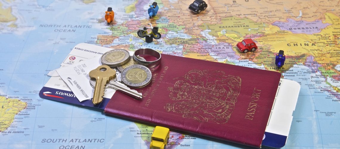 29842753 - british passport flight ticket and personal belongings displayed on a world map  travel and vacation